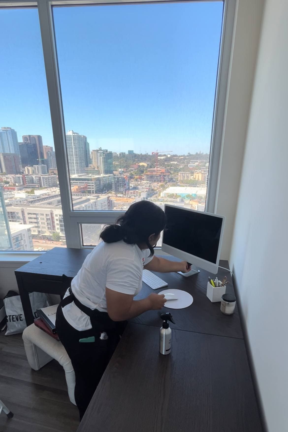 Mexi Maids staff member wiping a desk in a professional facility